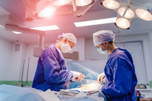grupo de cirurgioes na sala de cirurgia com equipamento cirurgico 116317 406 626x417 1920w